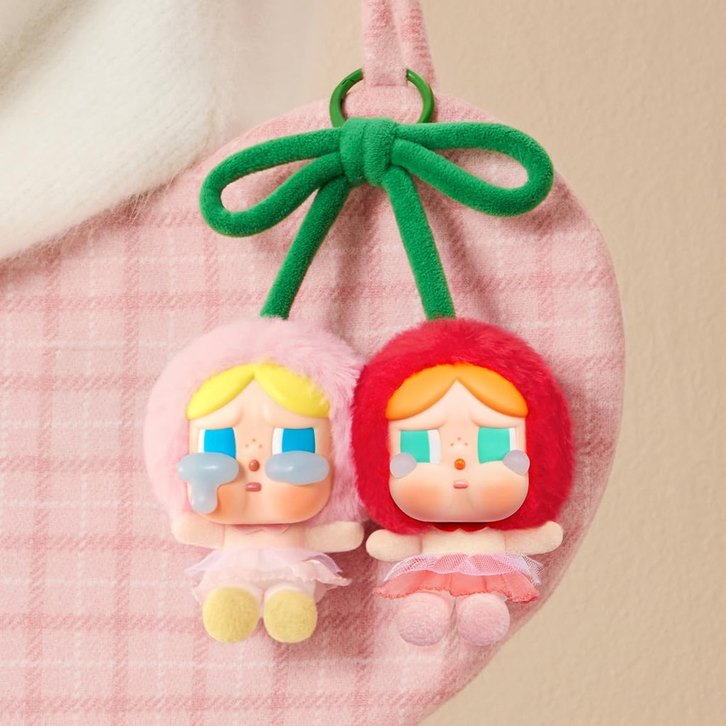 Pop Mart Labubu earrings with colorful hair and dresses, hanging from a pink drawstring bag.