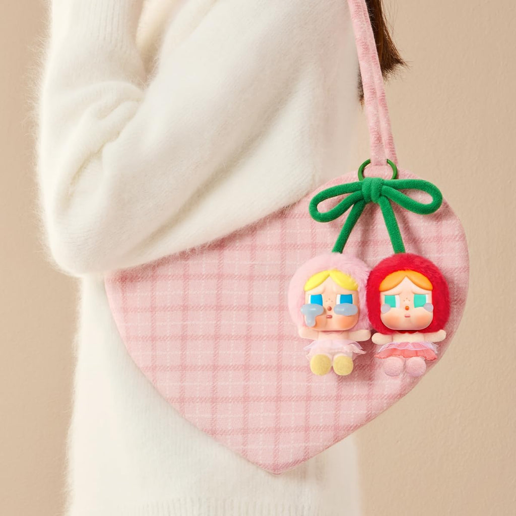 Small pink bag with Pop Mart Labubu keychains on a beige background