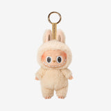 POP MART Labubu The Monsters keychain in a beige costume with a gold tag on a white background