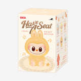 Packaging with a Pop Mart Labubu character and text 'Have A Seat' on a white background