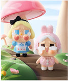 Two Pop Mart Labubu on a whimsical background with a pink mushroom and green landscape.