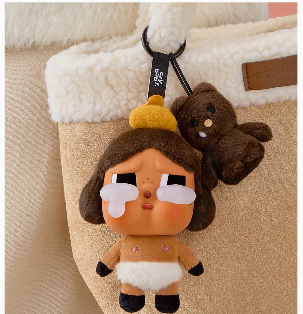 Pop Mart Labubu keychain with cartoon character and small brown bear on a beige bag.