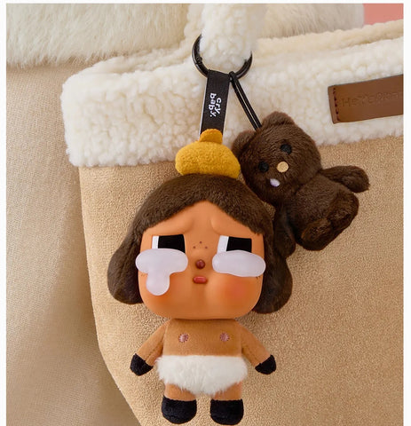 Pop Mart Labubu keychain with cartoon character and small brown bear on a beige bag.