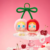 Two Pop Mart Labubu with colorful hair on a stand with cherries and a bow against a pink background