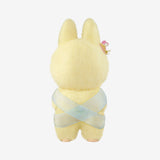 Yellow Monsters Labubu with a light blue ribbon on a white background