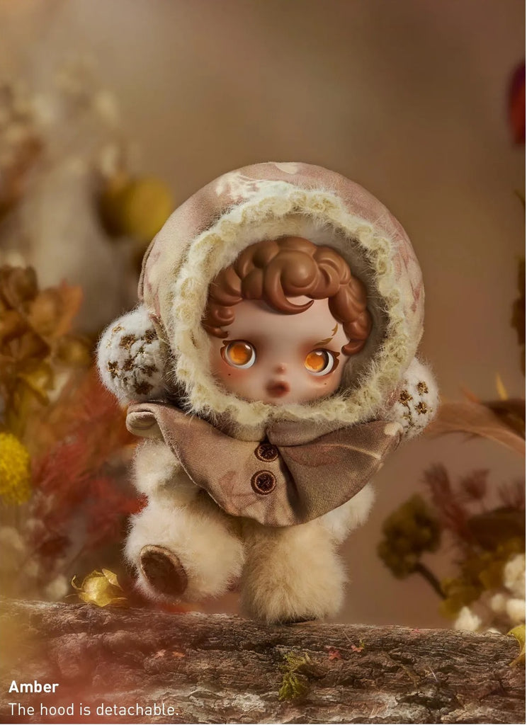 Small POP MART’s Skullpanda in a winter outfit with a detachable hood, standing on a wooden surface with a blurred natural background.