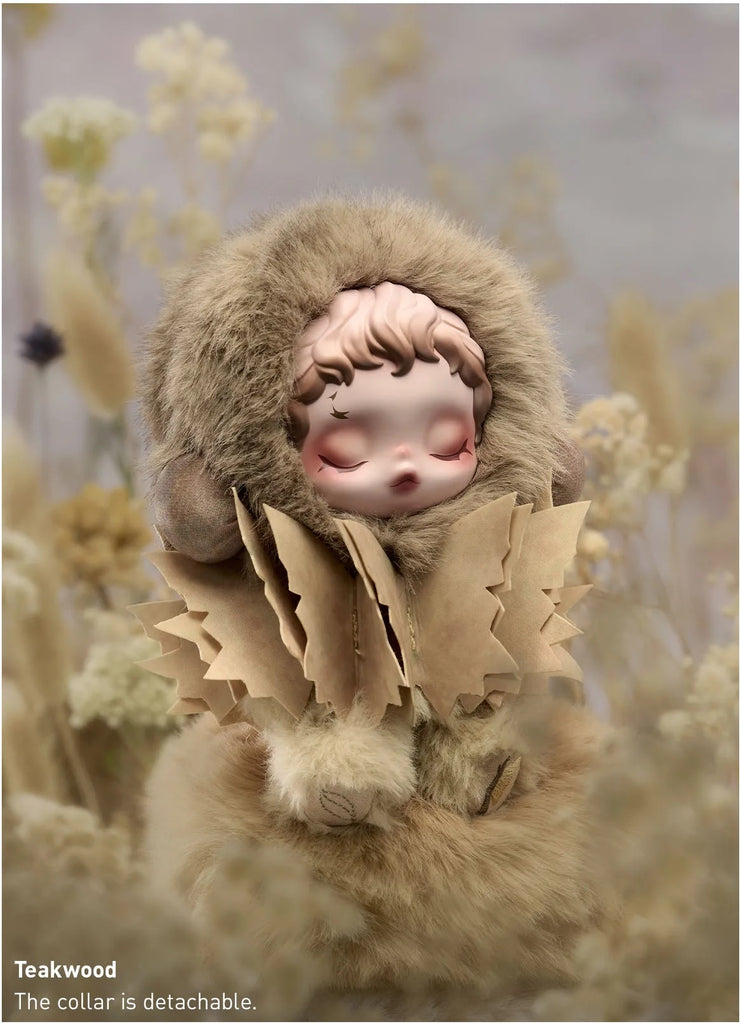 Stylized POP MART’s Skullpanda in a fur coat with a detachable collar amidst dried plants.