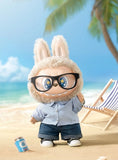 POP MART Labubu Flip with me with bunny ears and glasses on a beach with palm trees and a deck chair in the background.