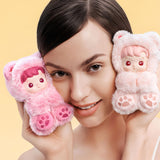 Woman holding two pink POPMART HACIPUPU Gummy Bear Series toys resembling cartoon characters against a yellow background