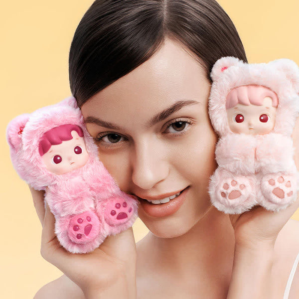 Woman holding two pink POPMART HACIPUPU Gummy Bear Series toys resembling cartoon characters against a yellow background