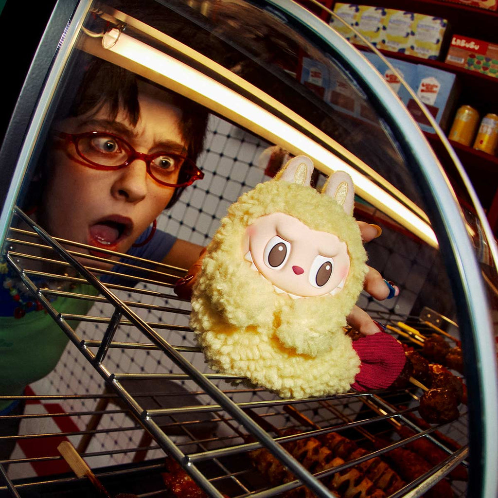 Person holding a POPMART the MONSTERS Wacky Mart Series Earphone Case inside an oven with a surprised expression.