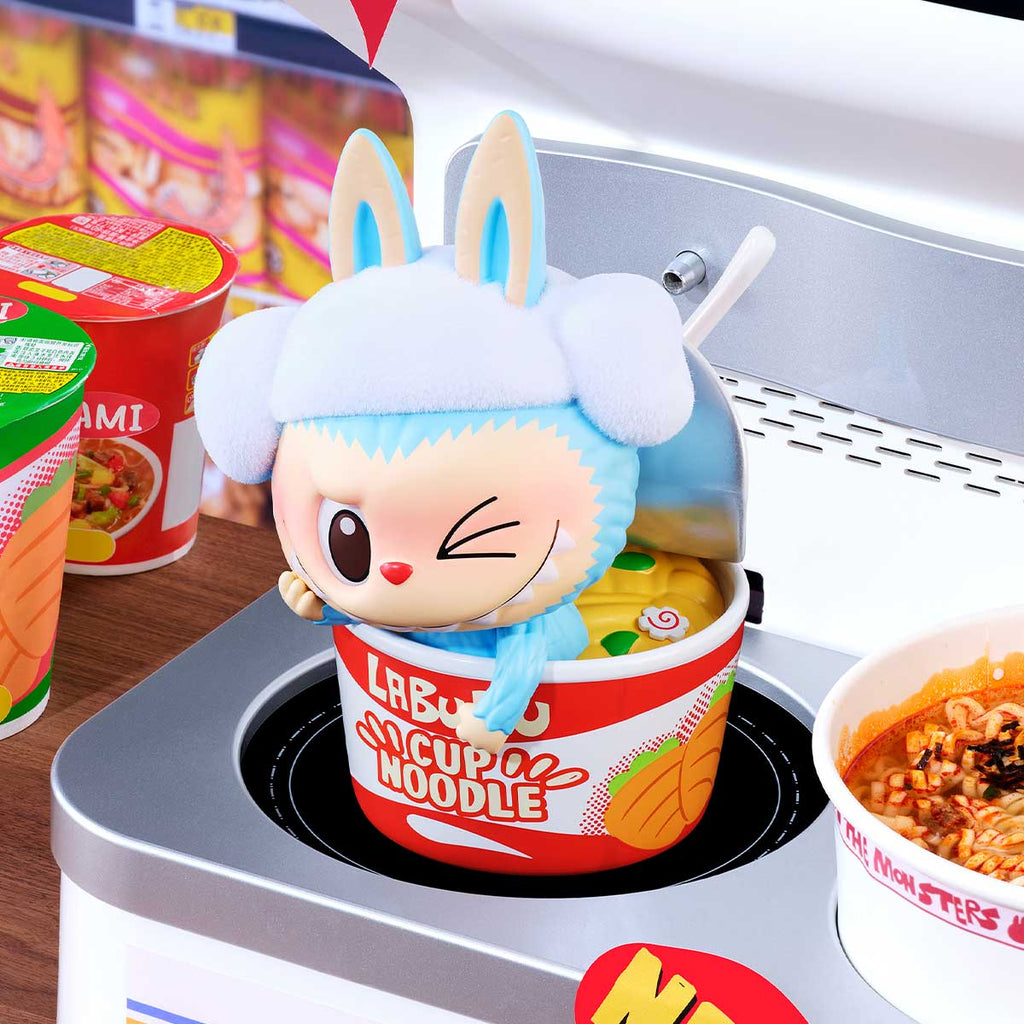 Pop Mart Labubu with rabbit ears in a cup of noodles container on a stove