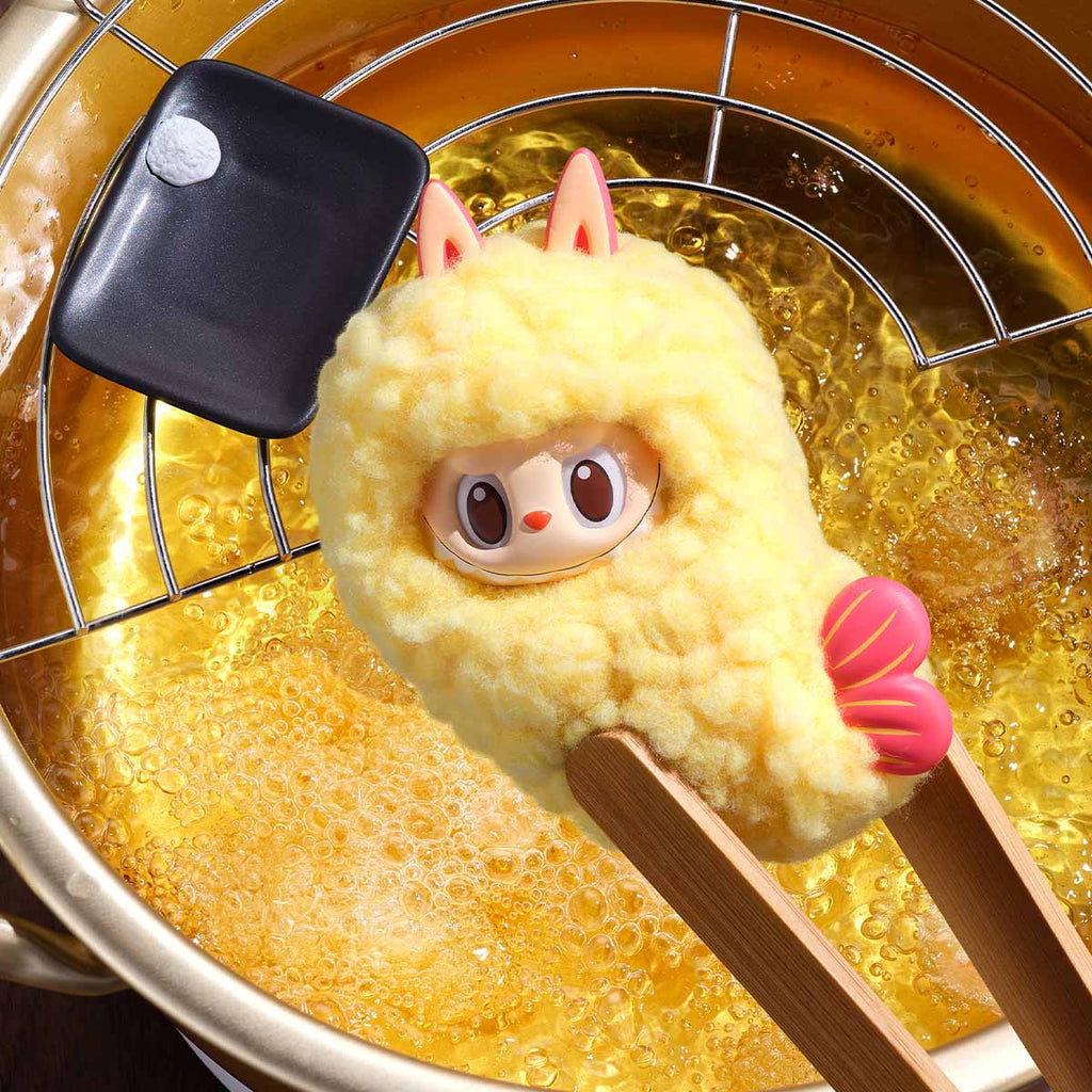 Toy chicken being fried in oil with a spatula