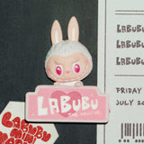 Pop Mart the Labubu Monsters with bunny ears and pink heart eyes, standing on a pink platform with 'LABUBU' branding.