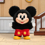 Plush toy resembling a well-known character in a room with wooden floor and wall.