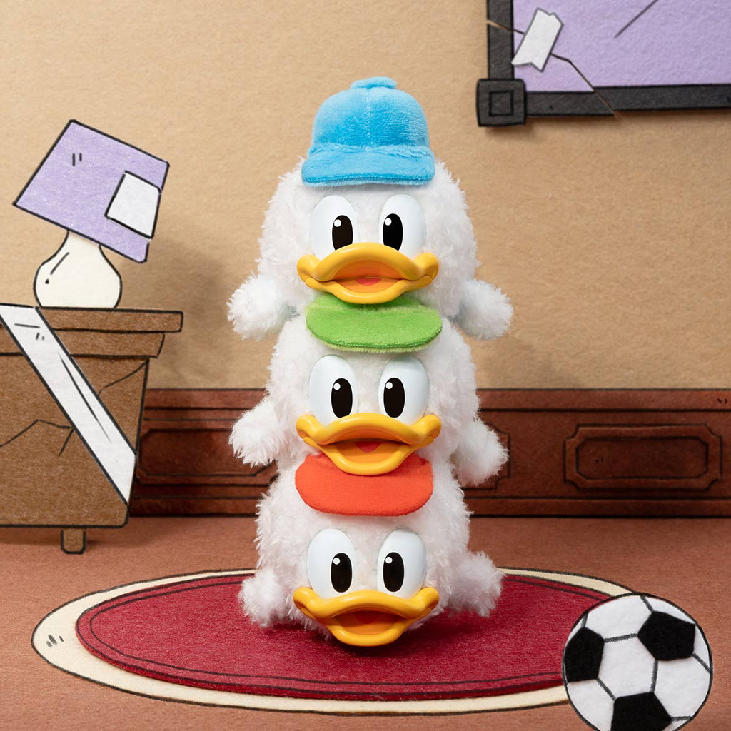 Stacked plush toys of Donald Duck in a room setting with a lamp and soccer ball.