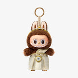 POP MART Good luck to you  keychain with a character in a brown hood and gold accents on a white background