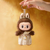 POP MART Good luck to you keychain of a character in a costume held by a hand against a yellow background