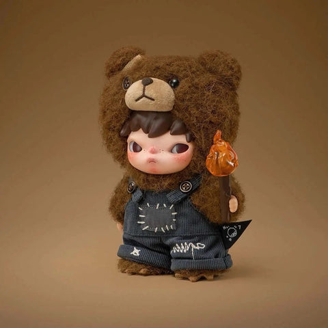 POP MART Hirono Vinyl Plush Art Doll wearing blue overalls on a brown background