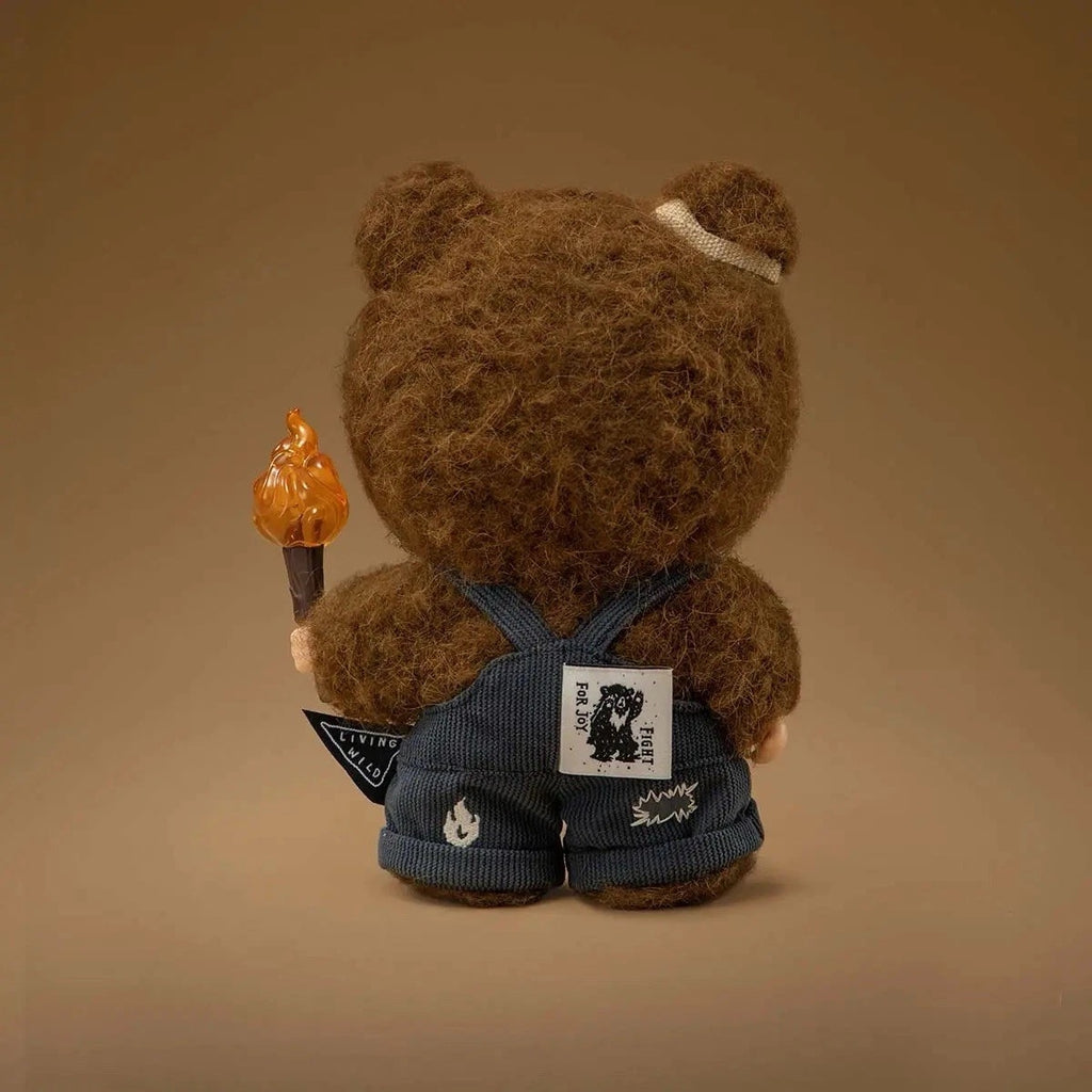 Brown POP MART Hirono Vinyl Plush Art Doll with a torch and denim overalls on a beige background