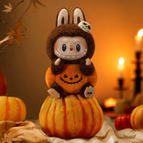 POP MART Hirono Sitting Pumpkin Plush toy in a bunny costume sitting on a pumpkin with Halloween decorations in the background.