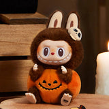POP MART Hirono Sitting Pumpkin Plush toy dressed in a Halloween costume with a pumpkin and ghost headband on a wooden surface.